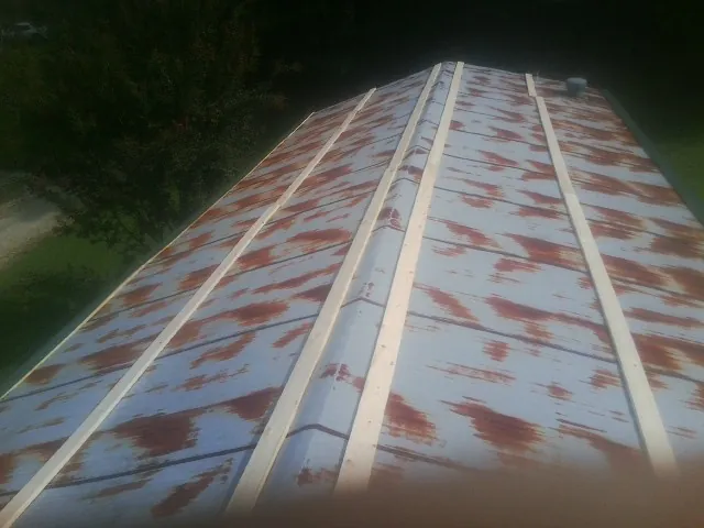 Rusted metal roof panels with new wood purlins before replacement — Storm Damage Roof Repair in Pine Island by Roofing Brothers